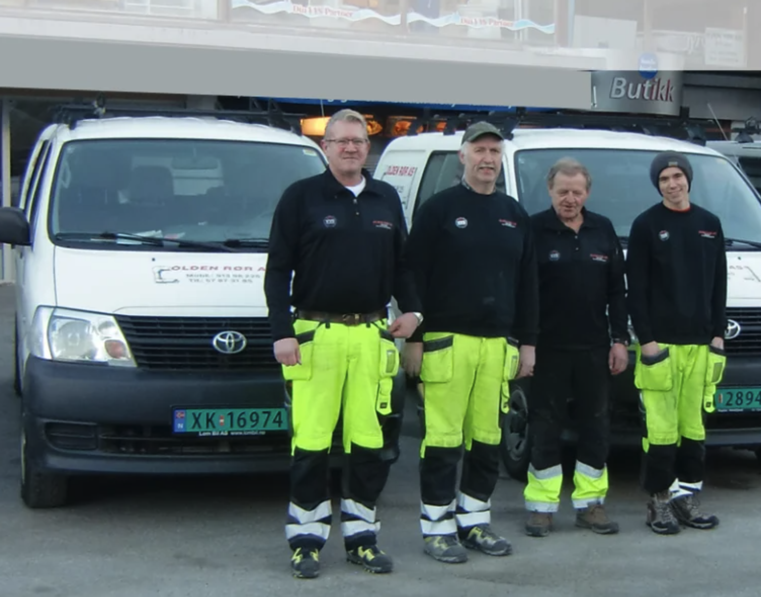 De ansatte hos Olden Rør AS — fire fagfolk foran servicebilene